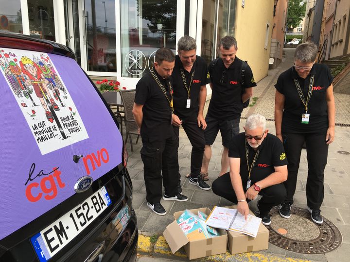 Accroupi au centre, Dominique Piron, le responsable de la voiture de la CGT,&nbsp;lors de la 4e étape entre Mondorf-les-Bains (Luxembourg) et Vittel (Vosges) du Tour de France, le 4 juillet 2017.&nbsp; (RAPHAEL GODET / FRANCEINFO)