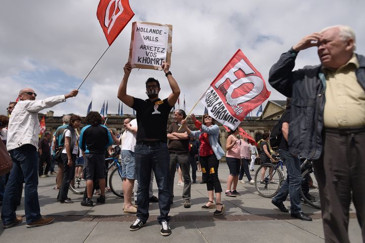 Un manifestant, la bouche recouverte par du scotch, brandit un panneau contre la loi Travail, mardi 5 juillet 2016 à Bordeaux (Aquitaine). (NICOLAS TUCAT / AFP)