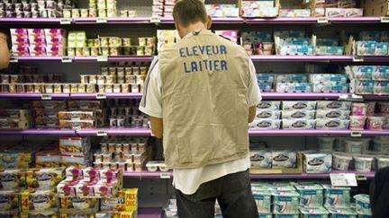 Un producteur de lait qui réétiquette les produits laitiers des rayons d'un supermarché, le 3 août 2010 à Dijon. (AFP PHOTO / JEFF PACHOUD)