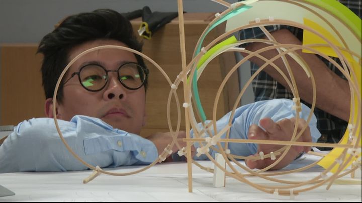 Mengzhi Zheng devant la maquette de&nbsp;Là où les vents se caressent. (C. Cherry-Pellat / France Télévisions)