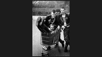 &quot;On dit que le punk est mort en 1977 mais il y avait des survivants. Je ne sais même pas qui est ce groupe ni d&#039;où il est originaire mais il a tous les attributs du punk : perfecto, badges, creepers et pantalons à zips.&quot;
 (Mick Mercer)