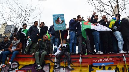 Des manifestants sur un container place de la République à Paris lors du rassemblement qui s'opposait à une cinquième candidature de Abdelaziz Bouteflika à la présidentielle d'avril 2019. Photo prise le 3 mars 2019. (JEAN-CHRISTOPHE BOURDILLAT / RADIO FRANCE)