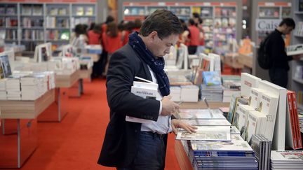 Un homme lit un livre lors de la foire internationale du livre, &agrave; Paris, le 20 mars 2014. (MARTIN BUREAU / AFP)