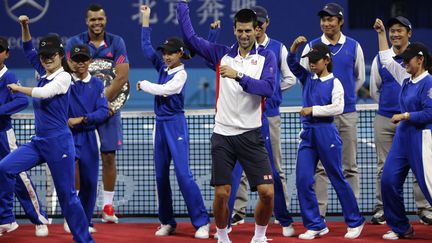 Le Serbe Novak Djokovic&nbsp;(C) danse avec des ramasseurs de balles &agrave; l'issue de sa finale remport&eacute;e face au Fran&ccedil;ais Jo-Wilfried Tsonga &agrave; l'open de tennis de Chine &agrave; P&eacute;kin, le 7 octobre 2012. (JASON LEE / REUTERS)