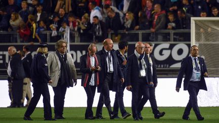 Bernard Joannin, le président de l'ASC, consulte son téléphone après l'écroulement du grillage du stade de la Licorne (FRANCOIS LO PRESTI / AFP)