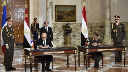 Le pr&eacute;sident &eacute;gyptien Abdel Fattah Al-Sissi, le ministre fran&ccedil;ais de la D&eacute;fense Jean-Yves Le Drian et son homologue &eacute;gyptien signe l'acghat d'avions Rafale l'Egypte au Caire le 16 f&eacute;vrier 2015 (MARTIN BUREAU / AFP)