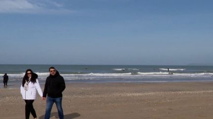 Dans le Calvados, les vacanciers profitent du beau temps pour se promener sur les bords de mer de Trouville-sur-Mer. Un restaurateur se réjouit d'une hausse de la fréquentation, mais redoute les effets du réchauffement climatique sur le long terme. (FRANCE 2)