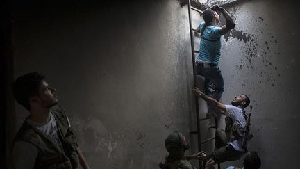 Un rebelle lance une grenade artisanale vers une position de l'armée. (AFP PHOTO / FABIO BUCCIARELLI)