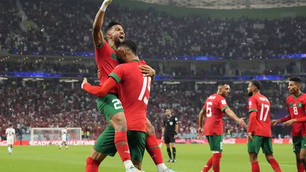 Les Marocains fêtent l'ouverture du score face au Portugal, à Doha, le 10 décembre 2022. (MARTIN MEISSNER/AP/SIPA)