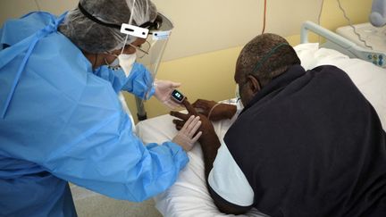 Une infirmière mesure la saturation en oxygène d'un patient atteint de Covid-19, le 30 septembre 2021 à l'hôpital de Nouméa (Nouvelle-Calédonie). (THEO ROUBY / AFP)