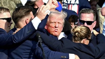 L'ex-président américain Donald Trump blessé à l'oreille après une tentative d'assassinat par balle au cours d'un meeting, samedi 13 juillet, à Butler en Pennsylvanie (Etats-Unis). (TAKAYUKI FUCHIGAMI / YOMIURI / AFP)