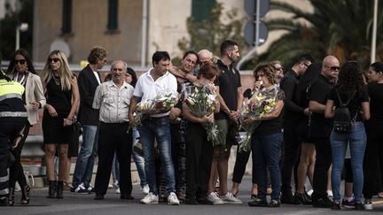 Des proches des victimes de l'effondrement du pont Morandi se recueillent et observent une minute de silence, le 14 septembre 2018, à Gênes (Italie), un mois après la tragédie.&nbsp; (MARCO BERTORELLO / AFP)