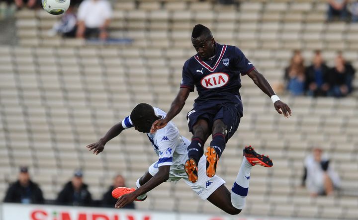 L'attaquant bordelais Henri Saivet (en bleu) prend le meilleur sur le milieu bastiais Adama Ba (en blanc), lors du match Bordeaux-Bastia le 24 ao&ucirc;t 2013.&nbsp; (NICOLAS TUCAT / AFP)