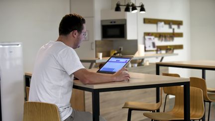 Un homme télétravaille dans sa cuisine. (SYLVIE CAMBON / MAXPPP)