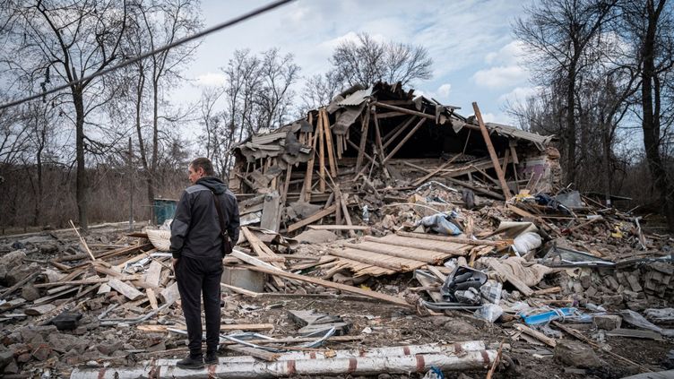 Un homme constate les débris d'un bâtiment endommagé à Kostyantynivka (Ukraine), le 24 mars 2023. (IGNACIO MARIN / ANADOLU AGENCY / AFP)