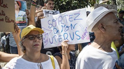 Une manifestante tient une pancarte "Sortez de mon utérus" à l'extérieur du tribunal où se tient le procès d'Hajar Raissouni, le 9 septembre 2019 à Rabat, capitale du Maroc. (FADEL SENNA / AFP)