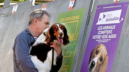 Un homme et son chien observent une affiche du Parti animaliste pour les élections européennes, le 22 mai 2019 à Lyon. (MAXPPP)