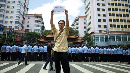 Un manifestant contre l'usine de paraxyl&egrave;ne brandit une banni&egrave;re appelant &agrave; un r&eacute;f&eacute;rendum, le 16 mai 2013 &agrave; Kunming (Chine). ( AFP )