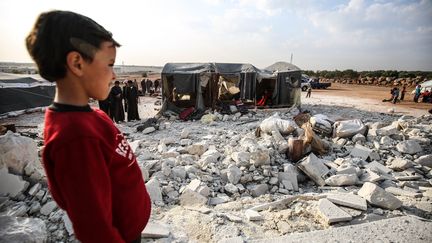 Un enfant face aux débris de bâtiments détruits par l'aviation russe dans la région de Idleb en Syrie, le 9 novembre 2019.&nbsp; (IZEDDIN IDLIBI / ANADOLU AGENCY / AFP)