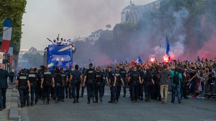 Les joueurs de l'équipe de France défilent face à la foule après leur victoire en Coupe du monde, le 16 juillet 2018, avenue des Champs-Elysées à Paris. (SERGE TENANI / CROWDSPARK / AFP)