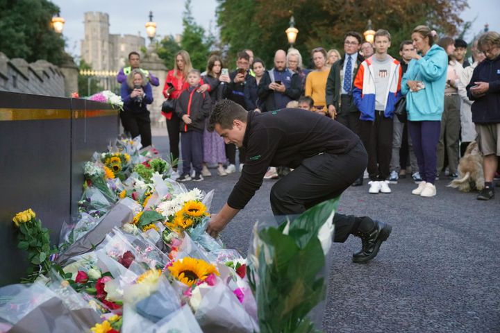 Un homme dépose des fleurs devant le palais de Buckingham à Londres (Royaume-Uni), après la mort d'Elizabeth II, le 8 septembre 2022. (MAXPPP)