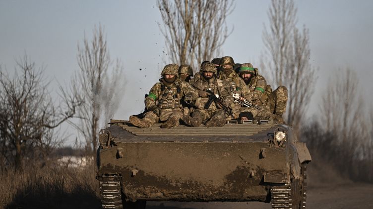 Des soldats ukrainiens se déplacent en direction de Bakhmout, dans l'est de l'Ukraine, le 13 mars 2023. (ARIS MESSINIS / AFP)