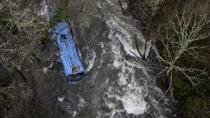 La carcasse d'un bus tombé dans une rivière en Galice (Espagne), le 25 décembre 2022. (BRAIS LORENZO / AFP)