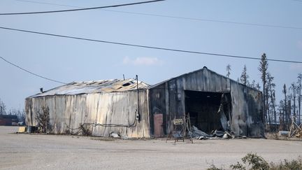 Un hangar de la ville d'Enterprise (Canada) est noirci par le passage des flammes, le 20 août 2023. (ANDREJ IVANOV / AFP)