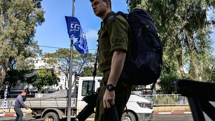 Un soldat israélien marche avec son équipement le long d’une rue à Nahariya dans le nord d’Israël, le 3 janvier 2024. (Alberto PIZZOLI / AFP)