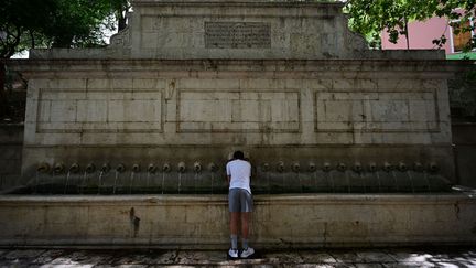 Un homme s'abreuve à une fontaine en pleine épisode de canicule, le 10 août 2023 à Xativa, au sud de Valence (Espagne). (JOSE JORDAN / AFP)