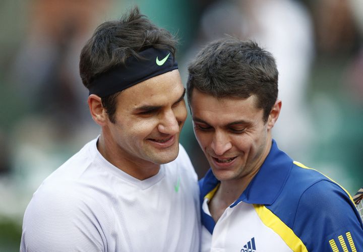 Roger Federer et Gilles Simon se congratulent après leur bataille au troisième tour de Roland-Garros, le 2 juin 2013. (MARTIN BUREAU / AFP)