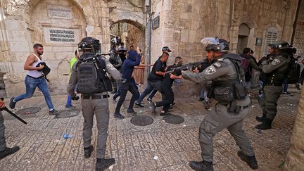 Des manifestants palestiniens fuient les forces de sécurité israéliennes lors d'affrontements dans la vieille ville de Jérusalem, le 10 mai 2021. (EMMANUEL DUNAND / AFP)