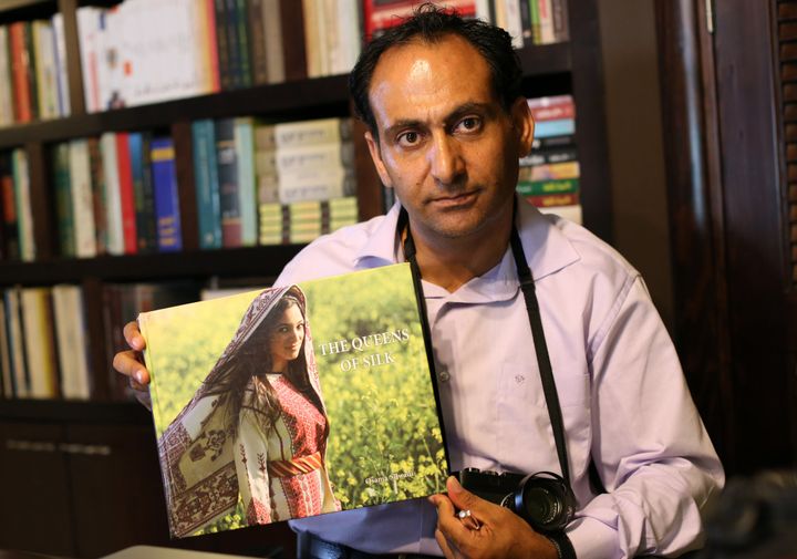 Osama Silwadi pose avec une de ses photos en 2014
 (ABBAS MOMANI / AFP)