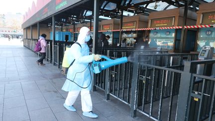 Un agent de santé désinfecte les salles de départ et d'attente de la gare de Pékin, le 4 février 2020. (KOKI KATAOKA / YOMIURI)