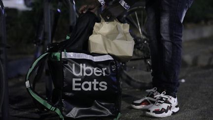 Un livreur Uber Eats livre un plat à domicile, à Colmar le 16 octobre 2021. (VINCENT VOEGTLIN / MAXPPP)