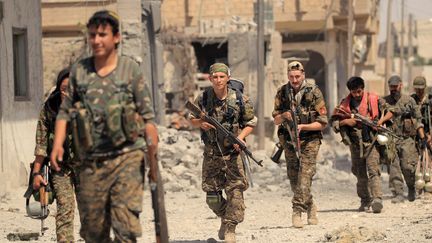 Des memrbes des&nbsp;Forces démocratiques syriennes avancent contre les djihadistes de l'Etat islamique dans le quartier Seif Al Dawla, à Raqqa, le 9 août 2017. (ZOHRA BENSEMRA / REUTERS)