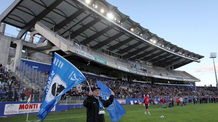 Un supporter bastiais tient un drapeau de son club au stade Armand Cesari de Furiani.&nbsp; (PASCAL POCHARD CASABIANCA / AFP)