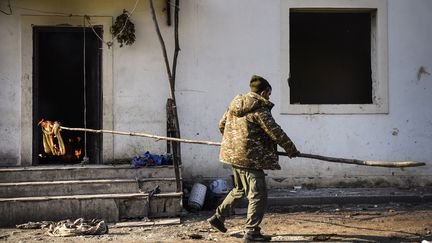 Un habitant du village de&nbsp;Charektar, dans la région du Haut-Karabakh, brûle sa maison, le 14 novembre 2020. (ALEXANDER NEMENOV / AFP)