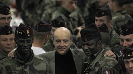 Le ministre de la Défense Alain Juppé au milieu des soldats français en Afghanistan, le 26 décembre 2010 (AFP/JOEL SAGET)