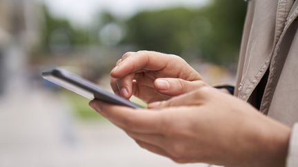 Une personne sur sont téléphone portable. Photo d'illustration. (EZEQUIEL SAMBRESQUI / MAXPPP)