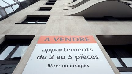 Une pancarte "A vendre" sur un immeuble parisinen. (LIONEL BONAVENTURE / AFP)