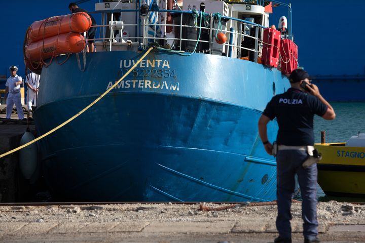 Un policier italien se tient devant le "Iuventa", navire de l'ONG allemande Jugend Rettet, dans le port de Trapani en Sicile (Italie), le 4 août 2017. (BELLINA FRANCESCO / AFP)