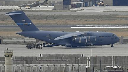 Des soldats américains montent à bord d'un avion de l'US Air Force à l'aéroport de Kaboul, le 30 août 2021.&nbsp; (AAMIR QURESHI / AFP)