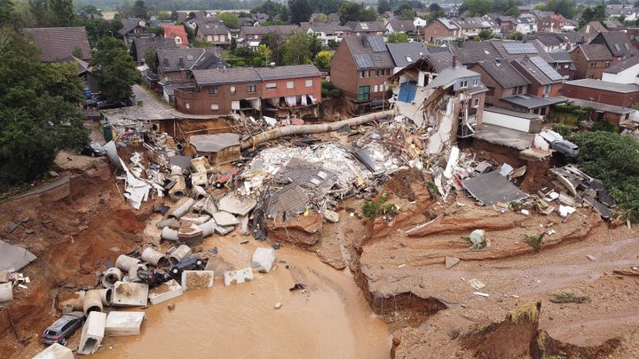 Sur cette image prise avec un drone, on voit ce cratère, rempli d'eau saumâtre, de carcasses de voitures, de tôle, de bitume. Des habitations ont été miraculeusement épargnées dans ce village d'Erfstadt-Blessem, à 40 kilomètres de Cologne, en Allemagne.&nbsp; (DAVID YOUNG / DPA VIA MAXPPP)