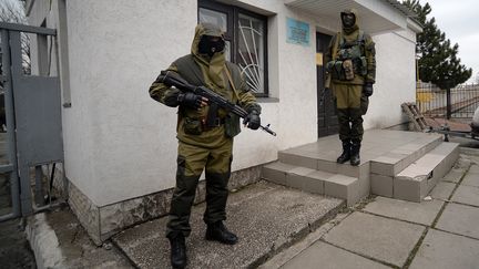 Deux militaires suppos&eacute;ment russes montent la garde devant un b&acirc;timent officiel &agrave; Simferopol (Ukraine), le 10 mars 2014. (FILIPPO MONTEFORTE / AFP)