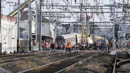 Des enquêteurs inspectent le train a déraillé en gare de Brétigny-sur-Orge (Essonne), le 13 juillet 2013. (KENZO TRIBOUILLARD / AFP)