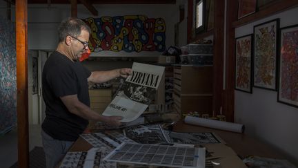 Jeff Ross tenant une affiche de Nirvana dans son atelier à Pancevo en Serbie. (VLADIMIR ZIVOJINOVIC / AFP)