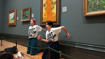 Deux militantes écologistes de "Just stop oil" lors de leur action contre la toile "Les tournesols" de Vincent Van Gogh, à la National Gallery de Londres (Royaume-Uni), le 14 octobre 2022 (HANDOUT / JUST STOP OIL)