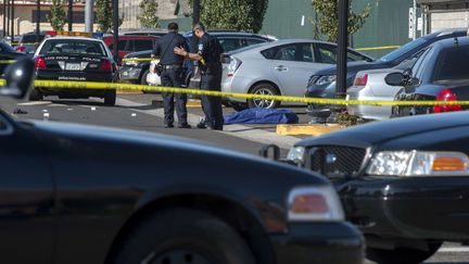 Des officiers de police se tiennent &agrave; c&ocirc;t&eacute; du corps de la victime d'une fusillade dans un campus de Sacramento (Californie), le 3 septembre 2015. (RENEE BYER / AP / SIPA)