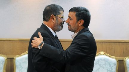 Le pr&eacute;sident &eacute;gyptien, Mohammed Morsi (&agrave; gauche), et le pr&eacute;sident iranien,&nbsp;Mahmoud Ahmadinejad (&agrave; droite), &agrave; T&eacute;h&eacute;ran (Iran) le 30 ao&ucirc;t 2012. (SAJAD SAFARI / IIPA / AFP)